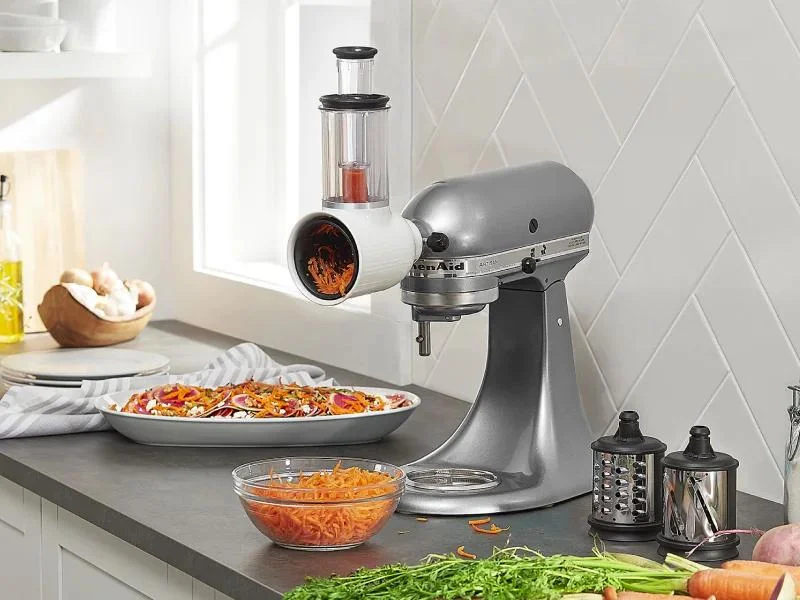 The KitchenAid slicer attachment is a stand-mixer accessory that uses the mixer's motor to slice and shred ingredients.